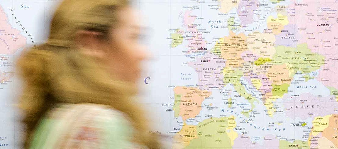 A map of Europe in a hallway with a person walking past